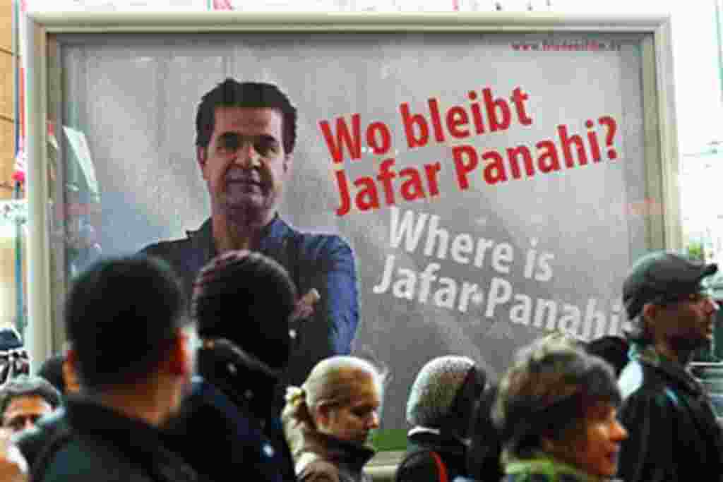 People walk in front of a poster showing Iranian filmmaker Jafar Panahi prior to the screening of the movie 'Offside' by Jajar Panahi at the International Film Festival Berlinale in Berlin, Germany, February 11, 2011