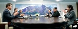 North Korean leader Kim Jong Un, second from right, talks with South Korean President Moon Jae-in, second from left, during a meeting at the border village of Panmunjom in Demilitarized Zone, April 27, 2018.