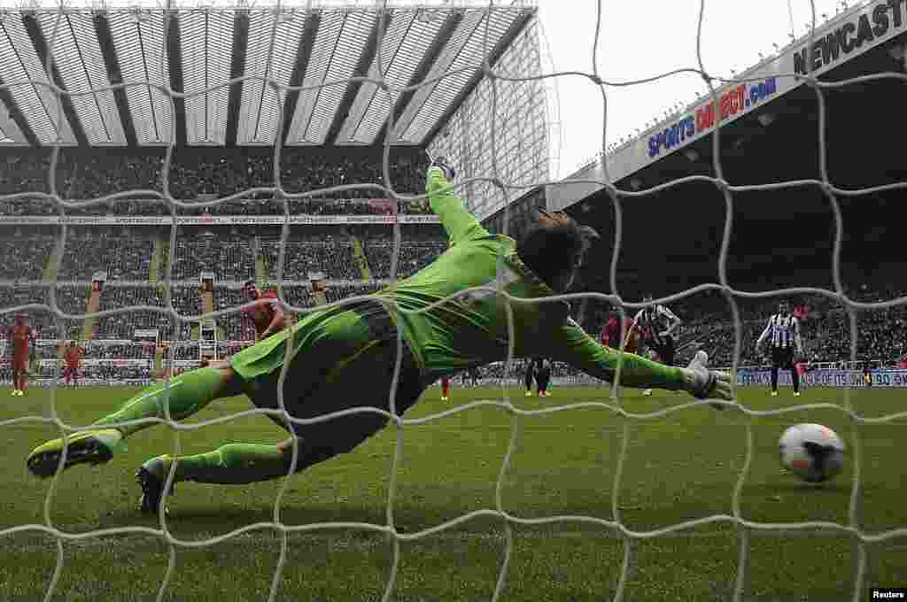 Liverpool's Steven Gerrard (C) shoots to score a penalty during their English Premier League soccer match against Newcastle United at St James' Park in Newcastle, northern England.