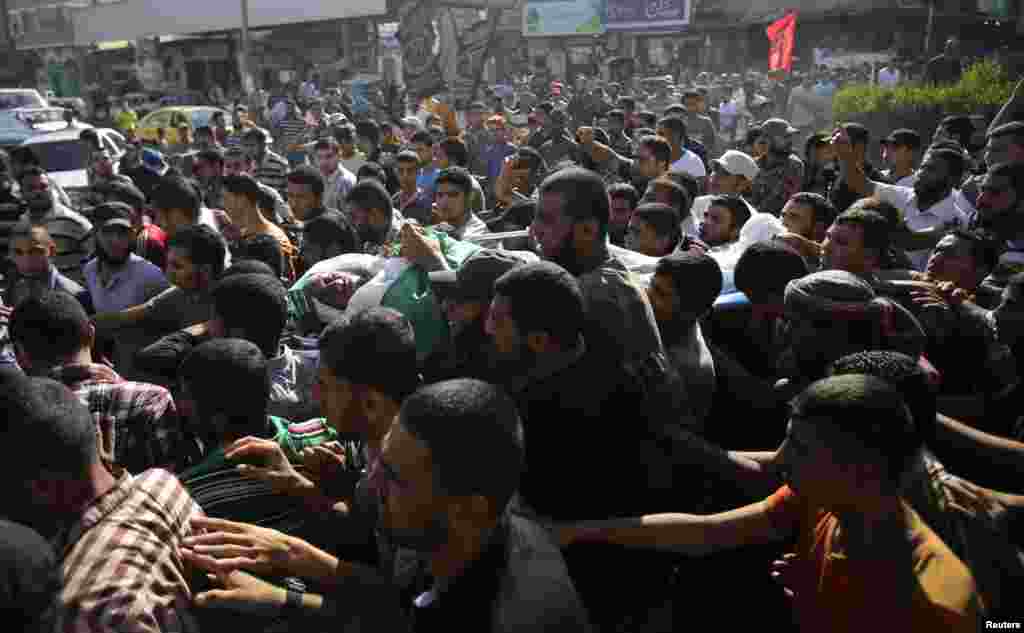 Mourners carry the body of a Hamas militant during his funeral in Rafah in the southern Gaza Strip, July 7, 2014.