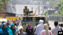 Seorang tentara berjaga-jaga di Lapangan Nahda, salah satu kamp demonstran pendukung Mohammed Morsi (12/8).