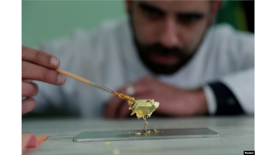 Portuguese chocolatier Daniel Gomes prepares a candy wrapped in pure 23-carat gold during international chocolate fair in Obidos, Portugal, March 16, 2018.