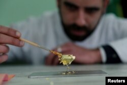 Portuguese chocolatier Daniel Gomes prepares a candy wrapped in pure 23-carat gold during international chocolate fair in Obidos, Portugal, March 16, 2018.