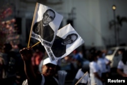 A street vendor sells flags of the late archbishop of San Salvador Oscar Arnulfo Romero during a procession in San Salvador, May 22, 2015.