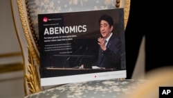 FILE - Pamphlets entitled "Abenomics" are laid out on chairs before a bilateral meeting between Japanese Prime Minister Shinzo Abe and visiting U.S. President Donald Trump, at Akasaka Palace, in Tokyo, Japan, Nov. 6, 2017.