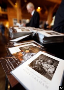 A stack of remembrance brochures are placed at the entrance as people come to pay respects to Billy Graham during a public viewing at the Billy Graham Library in Charlotte, N.C., Feb. 26, 2018.