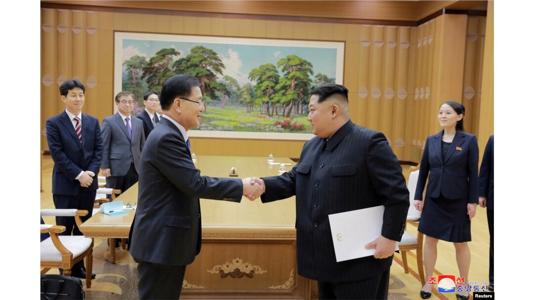 Pemimpin Korea Utara Kim Jong-un berjabat tangan dengan Chung Eui-yong yang memimpin delegasi Korea Selatan, dalam foto yang dirilis kantor berita pemerintah Korea Utara (KCNA), 6 Maret 2018.