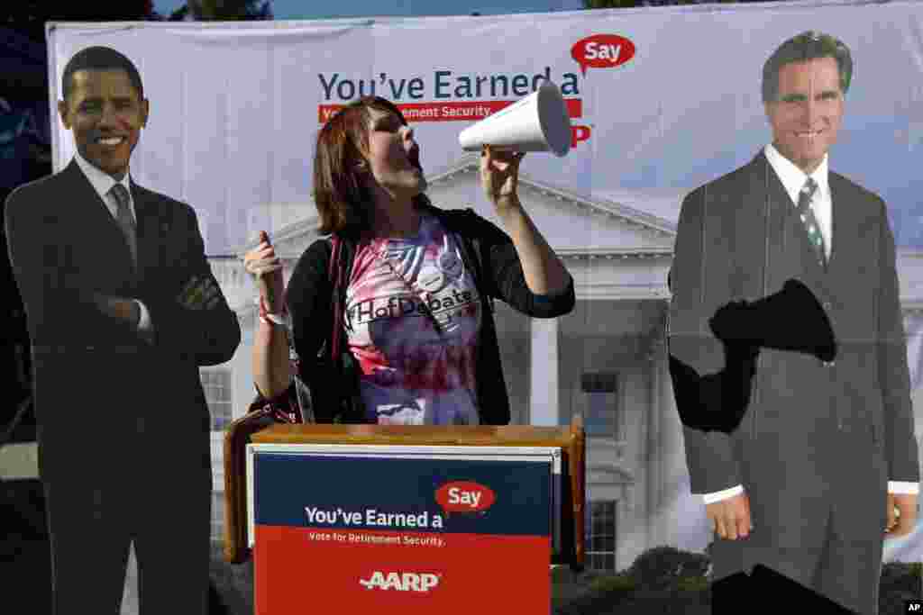 Hofstra University junior Corinne Mestemacher poses with cardboard cut outs of President Barack Obama and Republican presidential candidate Mitt Romney ahead of the presidential debate, Hempstead, New York, October 16, 2012.