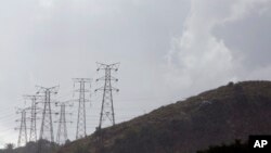 FILE - Electricity pylons snake across a hill in a Johannesburg suburb.