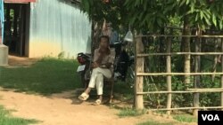 FILE: A village chief in Chi Kraeng district, Siem Reap province, is sitting watching the voters and a list of electors in hand for marking who voted or did not vote on July 29, 2019. (Thida Win/VOA Khmer)