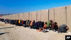 This photo provided by the Kurdish-led Syrian Democratic Forces shows some Islamic State group fighters, who were arrested by the Kurdish-led Syrian Democratic Forces after they attacked Gweiran Prison, in Hassakeh, northeast Syria, Jan. 21, 2022.