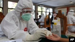Arhiva - Zdravstvena radnica obrađuje test na prisustvo antitela protiv koronavirusa, u Baliju, Indonezija, 11. septembra 2020. (AP Photo/Firdia Lisnawati)