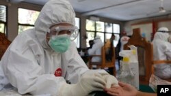 Seorang nakes (tenaga kesehatan) melakukan tes antibodi Covid-19 di sebuah kantor di Bali, Jumat, 11 September 2020. (AP Photo / Firdia Lisnawati)