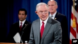 Attorney General Jeff Sessions, accompanied by, from left, National Counterintelligence and Security Center Director William Evanina, Director of National Intelligence Dan Coats, speaks during a briefing at the Justice Department in Washington, Aug. 4, 20