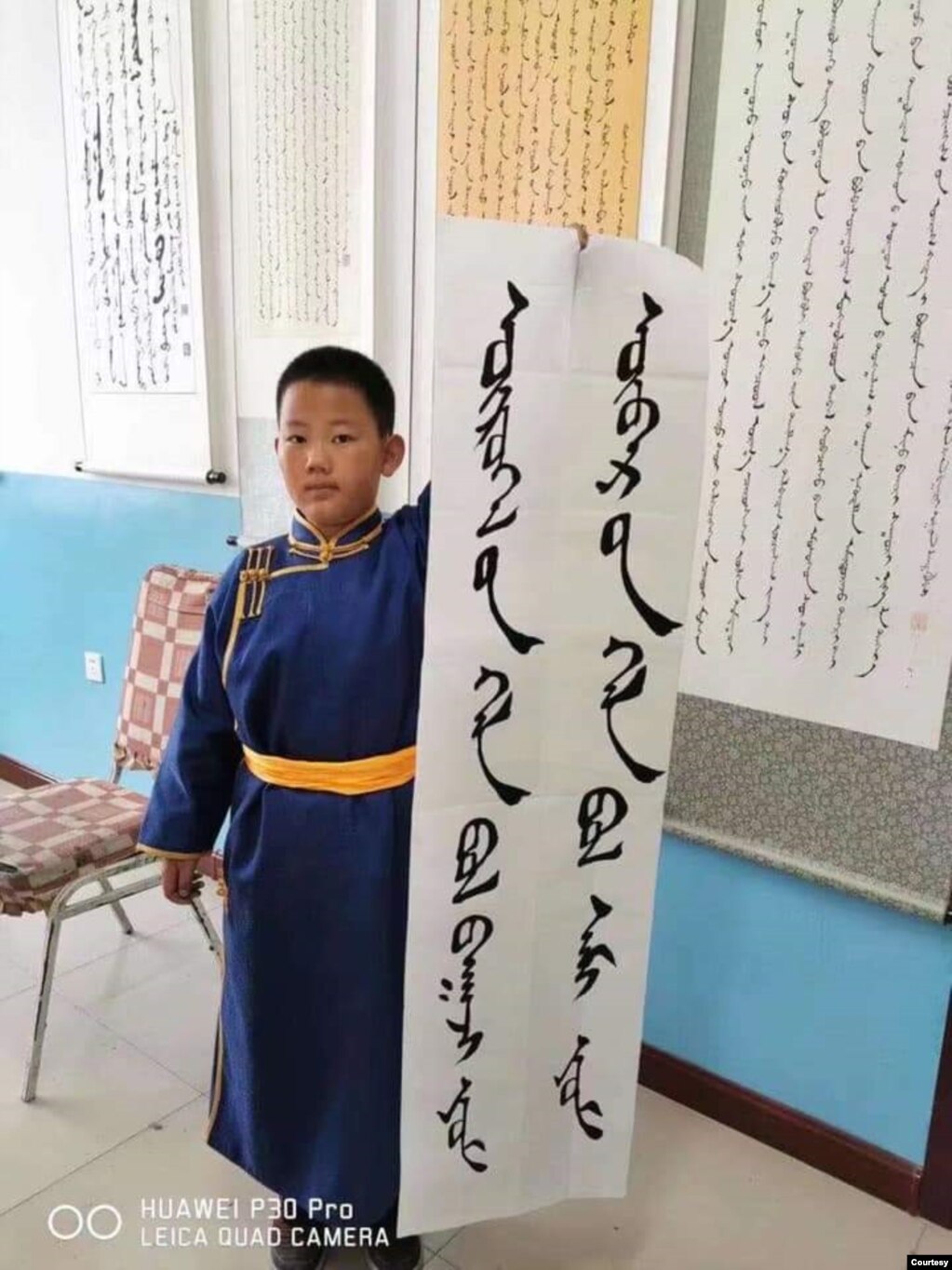 8月20日，内蒙古一名小学生手持“外语是工具，母语是灵魂”的标语，抗议当地教育部门将以汉语替代蒙语的“双语教学”计划。（照片由SMHRIC提供）(photo:VOA)