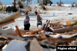 Christina Amanda, right, and Connie Huff, wait for an insurance adjuster as they look for their possessions at the site of their destroyed home in the aftermath of Hurricane Michael in Mexico Beach, Fla., Oct. 17, 2018.