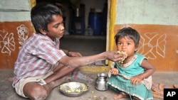 An Indian boy feeds his sister at their home in a slum in Hyderabad. Levels of under-nutrition in the country were "unacceptably high" despite impressive GDP growth, Prime Minister Manmohan Singh said Tuesday and added that the problem of malnutrition wa