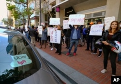 Uber and Lyft drivers demonstrate outside of Uber headquarters, May 8, 2019, in San Francisco. As Uber executives lure investors to the largest technology IPO this year, the men and women behind the wheels are pushing for higher wages and recognition for their part in building the company.