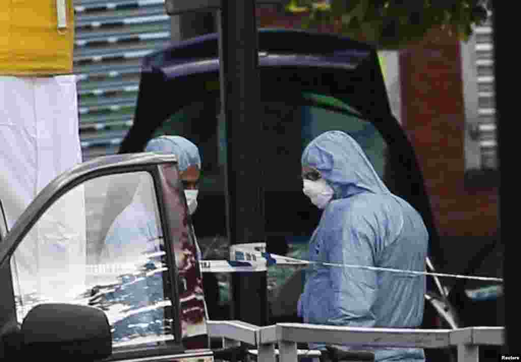 Police forensics officers investigate a car at a crime scene where one man was killed in Woolwich, southeast London May 22, 2013.