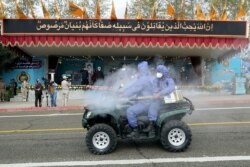 A handout picture provided by Iranian army official website on April 17, 2020 shows Iranian army soldiers wearing protective clothes and holding disinfection equipment against the coronavirus COVID-19 during the Iran army day parade in Tehran.