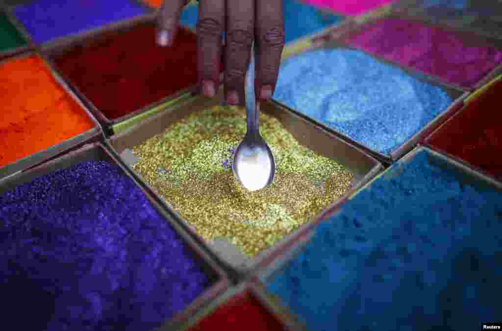 A street vendor spreads vermilion powder used for worship during the Tihar festival, also called Diwali, in Kathmandu, Nepal.