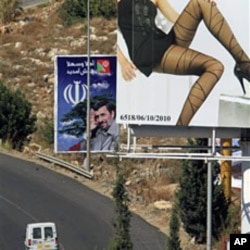 A poster of Iranian President Mahmoud Ahmadinejad (C) set on the Jiyeh highway, south of Beirut, 11 Oct 2010