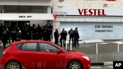 Police officers stand guard outside of the building of the Afrika newspaper office after it was attacked by supporters of the Turkish President Recep Tayyip Erdogan in the Turkish occupied northern part of the divided capital Nicosia, Cyprus, Jan. 22, 201