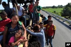 Doris Vanesa Perdomo y su hija Nicol, a la izquierda, hablan mientras viajan con otros inmigrantes centroamericanos en un camión en Loma Bonita, estado de Oaxaca, México, sábado 3 de noviembre de 2018. (Foto AP / Rodrigo Abd)