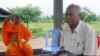 FILE - Meas Muth, right, sits next to a Buddhist monk at Anlong Veng district in Oddar Mean Chey province, Cambodia, July 23, 2006. Meas Muth was implicated in the 1975 Mayaguez incident in which at least 38 U.S. servicemen died.