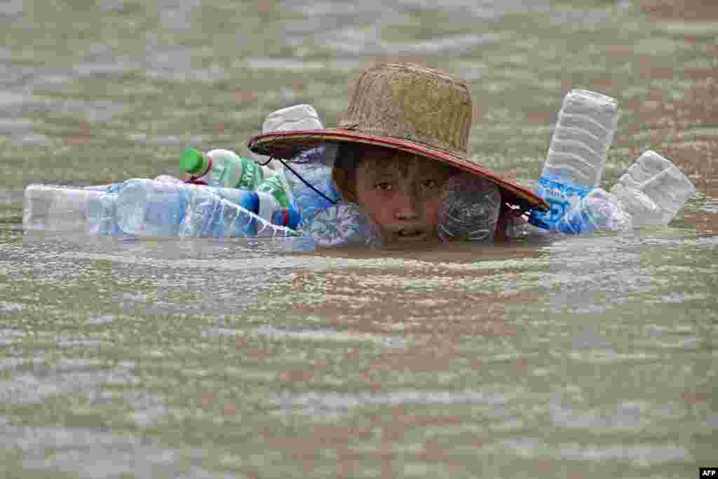 A boy swims in floodwaters at Kyaut Ye village near the Hinthada town in Myanmar&#39;s Irrawaddy Delta region.