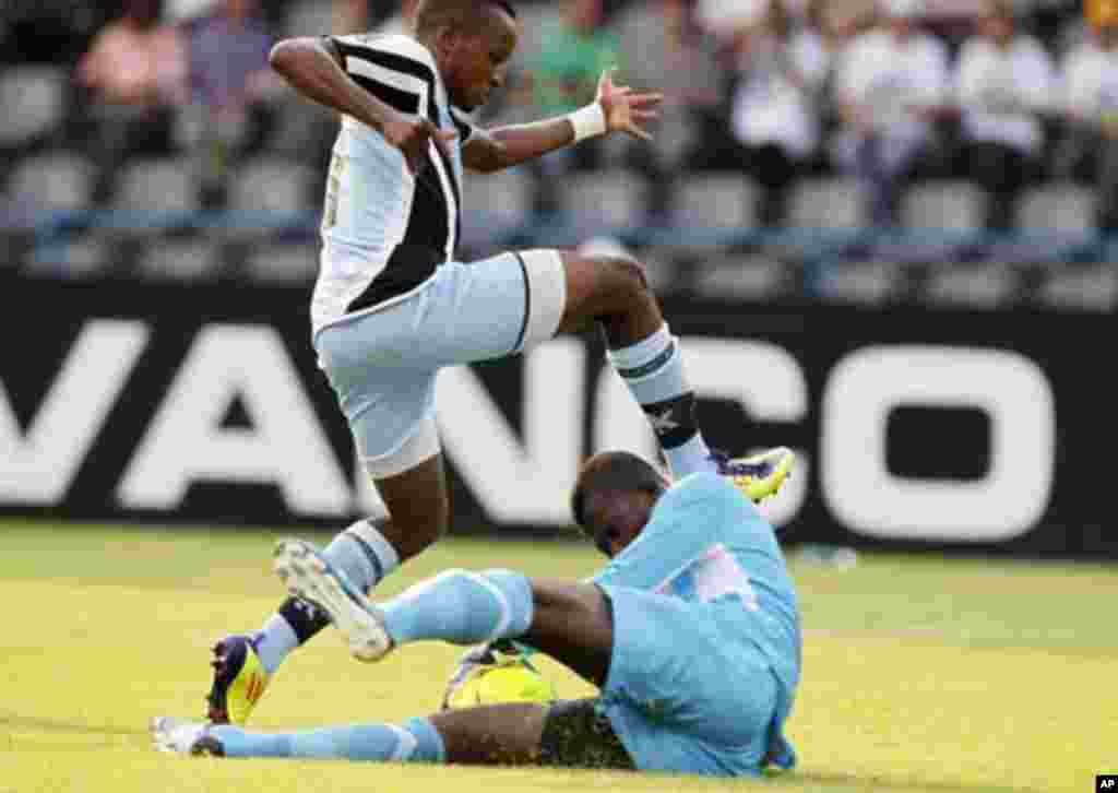 Guinea's goalkeeper Naby Yattara (bottom) makes a save from Botswana's Ofentse Nato during their African Nations Cup Group D soccer match at Franceville Stadium January 28, 2012.