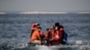 Des migrants, y compris des femmes et des enfants, dans un canot pneumatique, réagissent à l'approche de la côte sud de la Grande-Bretagne alors qu'ils traversent illégalement la Manche depuis la France le 11 septembre 2020.