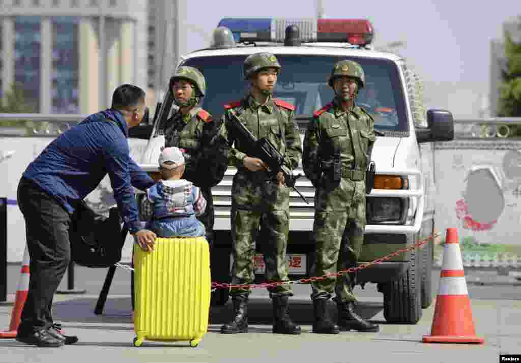 Armed paramilitary police officers stand guard at Beijing Railway Station. An assailant stabbed six people at a railway station in the southern Chinese city of Guangzhou, police and state media said.