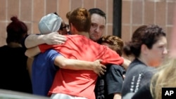 People react outside the unification center at the Alamo Gym, following a shooting at Santa Fe High School in Santa Fe, Texas.