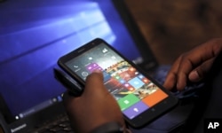 A Microsoft staffer uses a smartphone during the launch of the Windows 10 operating system.