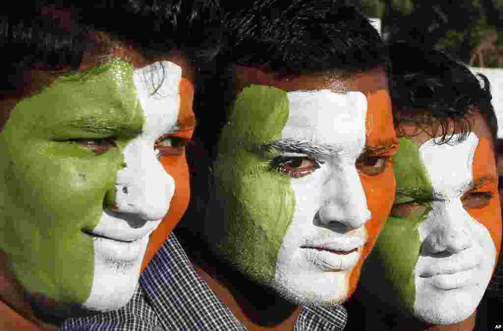 Indian cricket fans with their faces painted with the colors of the Indian flag, wait to enter the Sardar Patel Stadium, venue of the second Twenty20 cricket match between India and Pakistan, in Ahmadabad, India, December 28, 2012. 