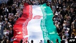 Demonstran pro-pemerintah melambaikan bendera nasional mereka dalam aksi unjuk rasa di kota suci Iran, Qom, sekitar 130 kilometer selatan Teheran, 3 Januari 2018.