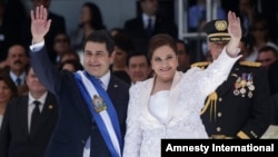 Honduras' President Juan Orlando Hernandez, left, and his wife Ana Rosalinda wave after his swearing in ceremony as new president in Tegucigalpa, Honduras, Jan. 27, 2014.