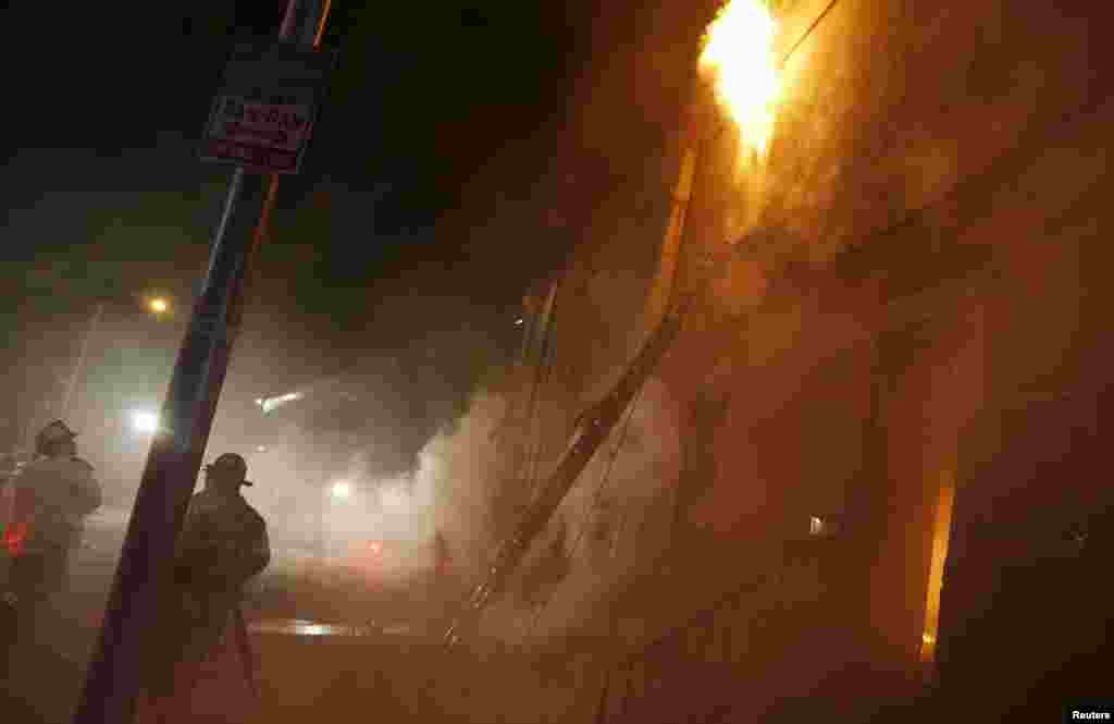 Firefighters battling a blaze on East Biddle street at Montford Avenue, Baltimore, April 28, 2015. 