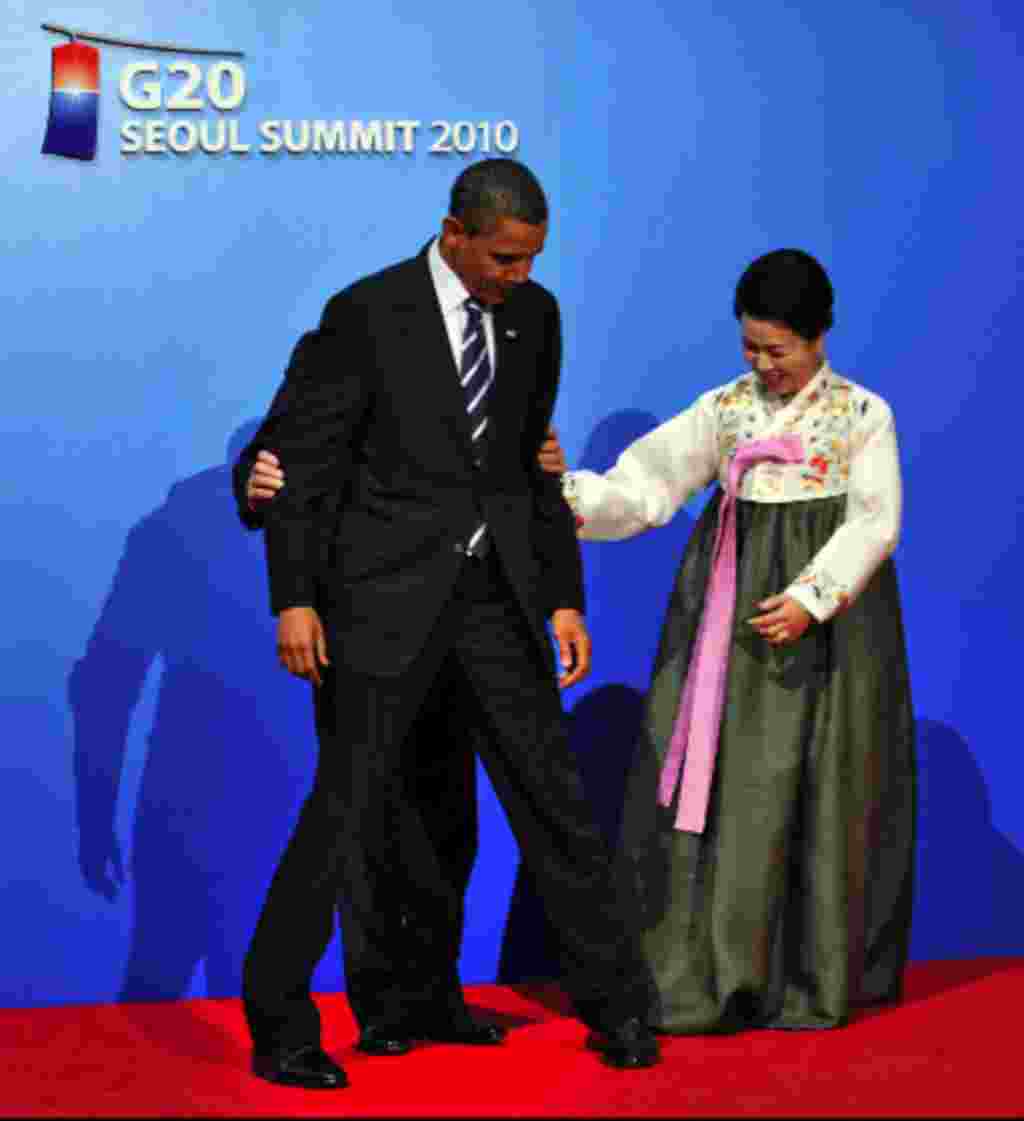 President Obama is moved to the correct spot by South Korean President Lee Myung-bak and his wife, Kim Yoon-ok, for a photo during the official reception ahead of the G-20 working dinner at the National Museum of Korea in Seoul. G-20 leaders started what