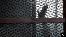Un membre des Frères musulmans dans une cage faisant office de box des accusés dans la prison de Tora, Égypte, le 22 août 2015.
