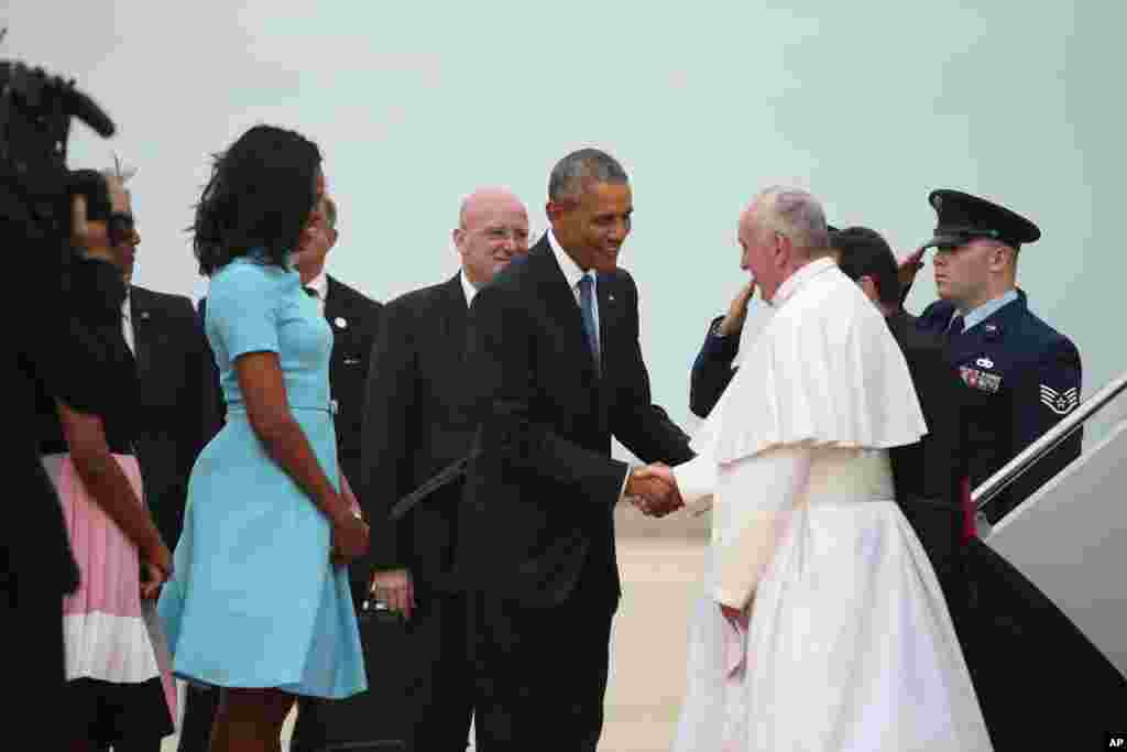 President Barack Obama and first lady Michelle Obama greet Pope Francis upon his arrival at Andrews Air Force Base, Maryland, Sept. 22, 2015. 
