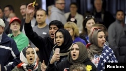 FILE - Young Muslims protest US Republican presidential candidate Donald Trump before being escorted out during a campaign rally in the Kansas Republican Caucus at the Century II Convention and Entertainment Center in Wichita, Kansas, March 5, 2016.