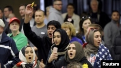 FILE - Young Muslims protest against US Republican presidential candidate Donald Trump before being escorted out during a campaign rally in the Kansas Republican Caucus, Wichita, March 5, 2016.