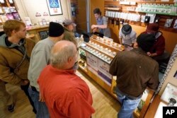FILE - Employees of Amazon Organics, a pot dispensary in Eugene, Ore., help customers purchase recreational marijuana, Oct. 1, 2015.