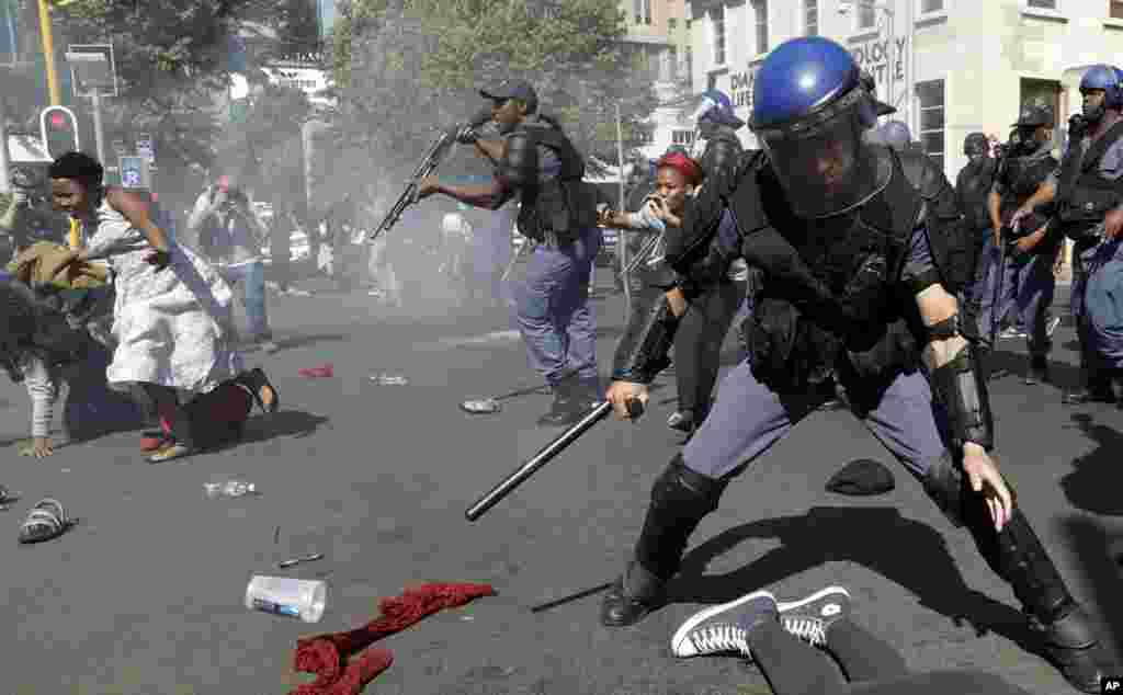Students run for cover as police fire stun grenades and rubber bullets in an attempt to disperse them, during their protest for free education in Johannesburg, South Africa.