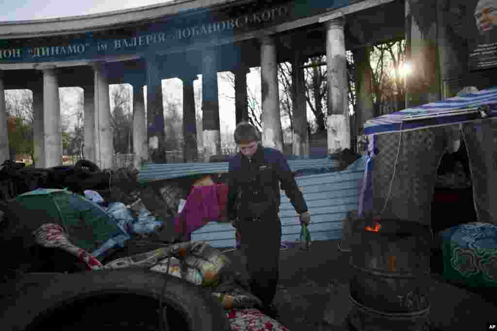 A man clears bottles at a barricade near the entrance to the stadium of Dynamo Kyiv soccer club in Ukraine. 