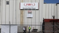 資料照片：位於科羅拉多州的JBS美國分部肉類包裝廠的員工戴著口罩在廠區走動。 (2020年4月8日)
