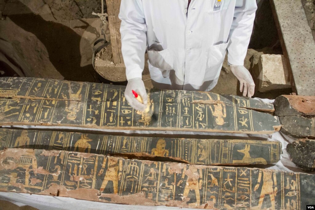 An Egyptian excavation worker restores a coffin found inside the Kampp 150 tomb in the Draa Abul Naga necropolis on Luxor’s West Bank, Egypt, Dec. 9, 2017. (H. Elrasam/VOA)