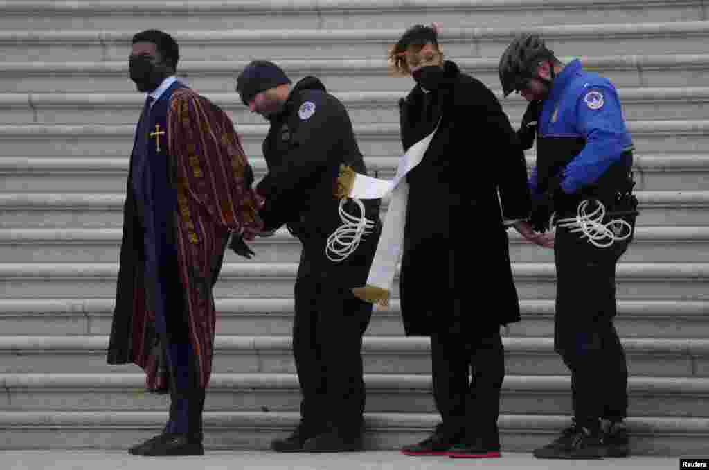 Faith leaders, including Rev. Stephen A. Green, are detained with students after staging a sit-in protest to urge the U.S. Senate to pass the Freedom To Vote: John R. Lewis Act, on the steps of the U.S. Capitol building in Washington, Jan. 18, 2022.